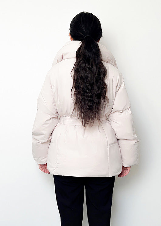 Modell trägt eine kurze Damen Steppjacke mit Taillengürtel – NAHA Fashion