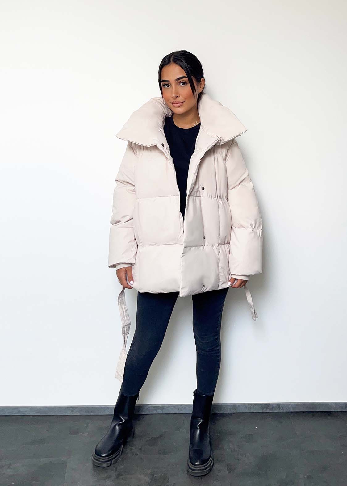 Modell trägt eine kurze Damen Steppjacke mit Taillengürtel – NAHA Fashion