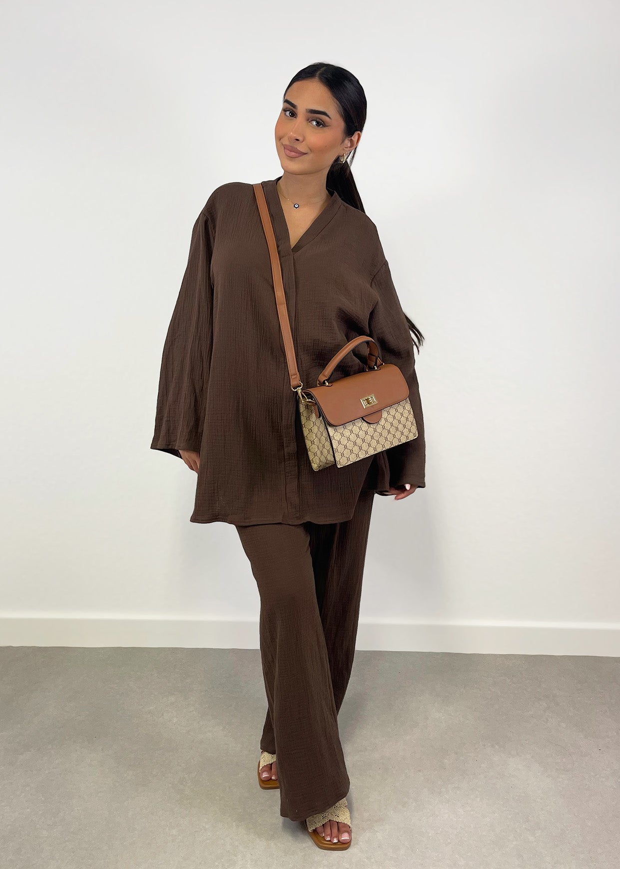 Frau trägt braunen Musselin-Zweiteiler mit weiter Hose und Oversize-Bluse