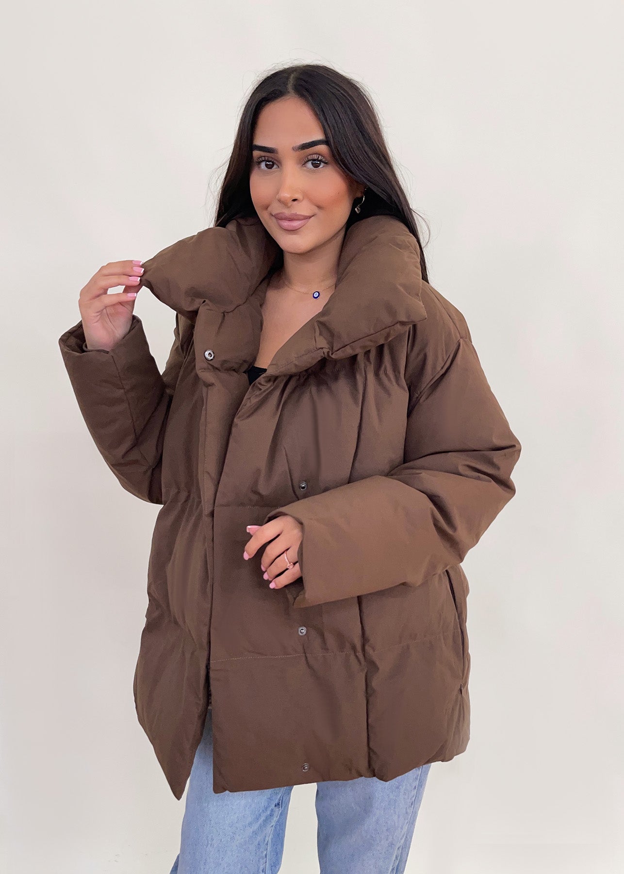 Modell trägt eine kurze Damen Steppjacke mit Taillengürtel – NAHA Fashion