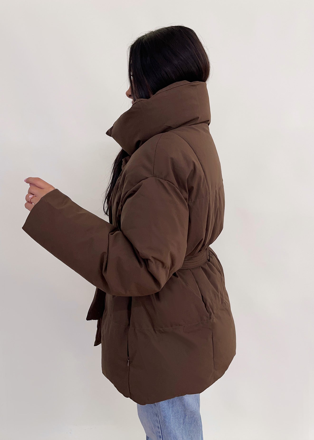 Modell trägt eine kurze Damen Steppjacke mit Taillengürtel – NAHA Fashion