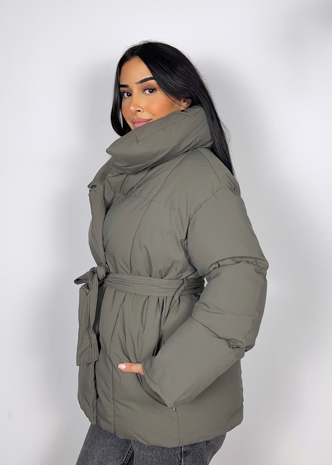Modell trägt eine kurze Damen Steppjacke mit Taillengürtel – NAHA Fashion