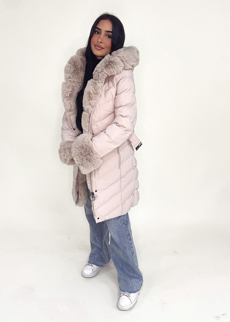 Modell trägt eine taillierte Damen Steppjacke mit Gürtel, Fellkragen und Fellärmeln – NAHA Wintermode