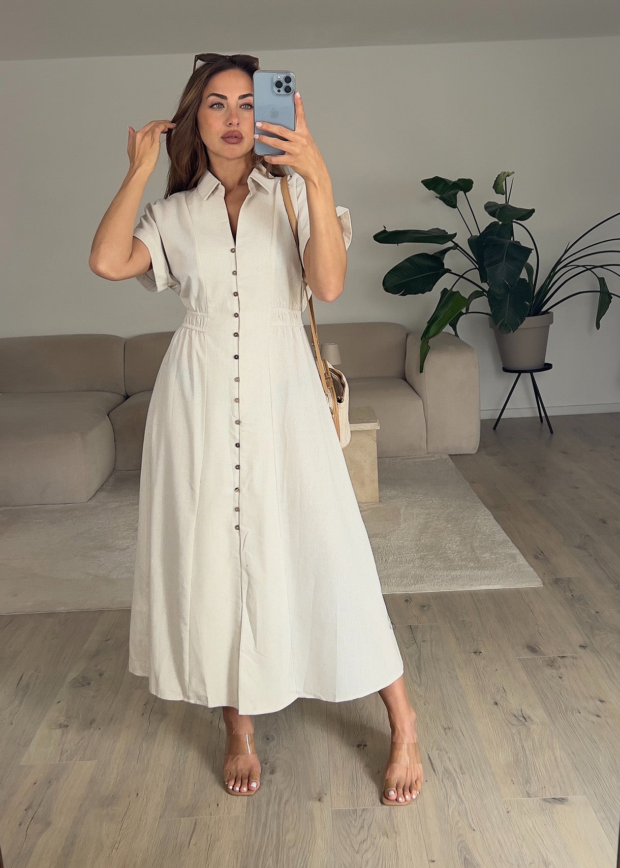 Frau trägt ein ärmelloses Hemdblusenkleid in Beige mit Knopfleiste – Sommerlook von NAHA