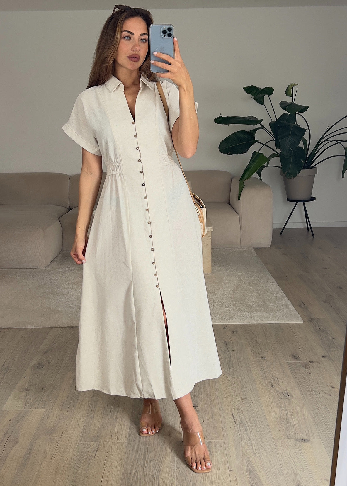 Frau trägt ein ärmelloses Hemdblusenkleid in Beige mit Knopfleiste – Sommerlook von NAHA