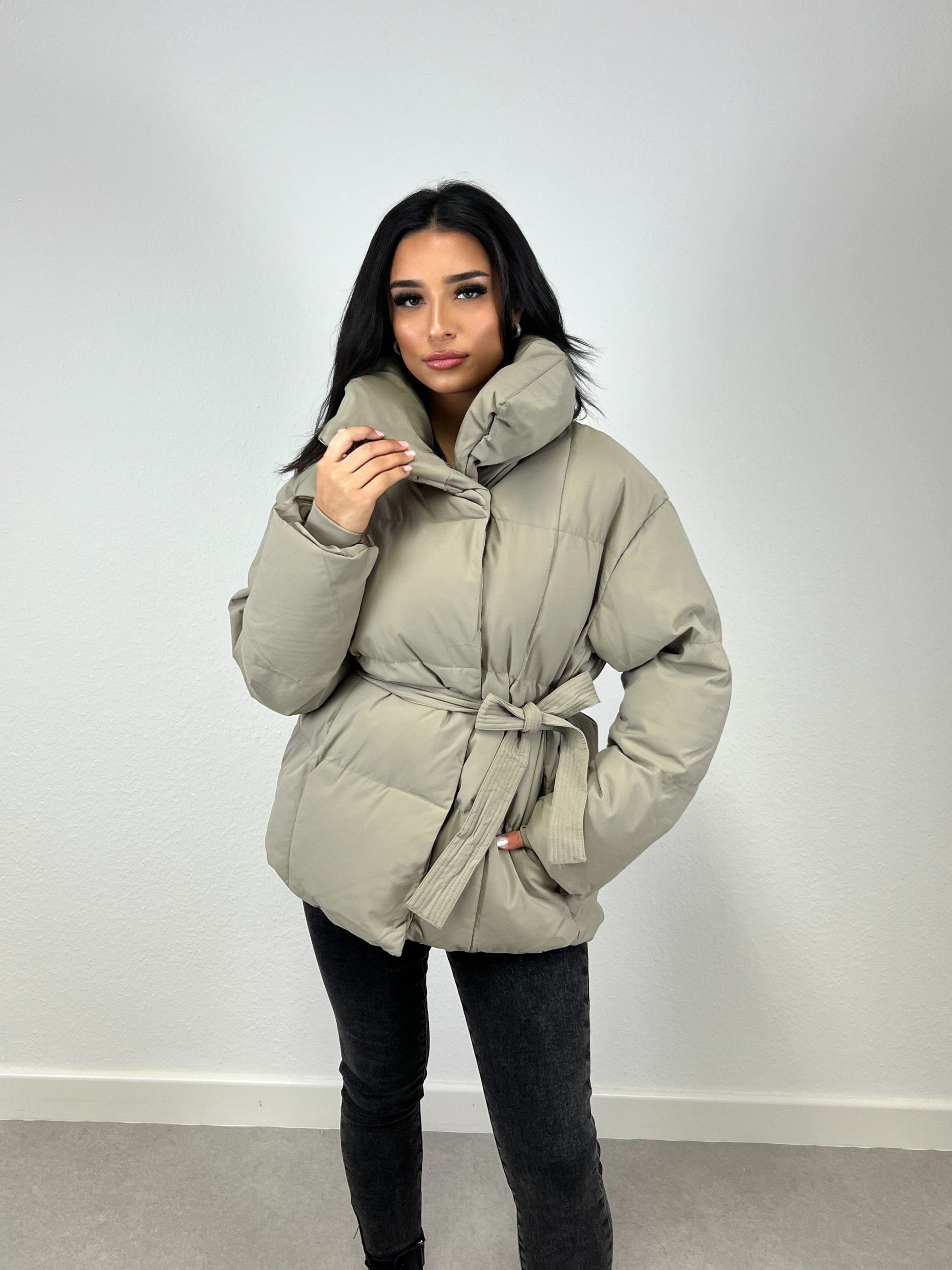 Modell trägt eine kurze Damen Steppjacke mit Taillengürtel – NAHA Fashion