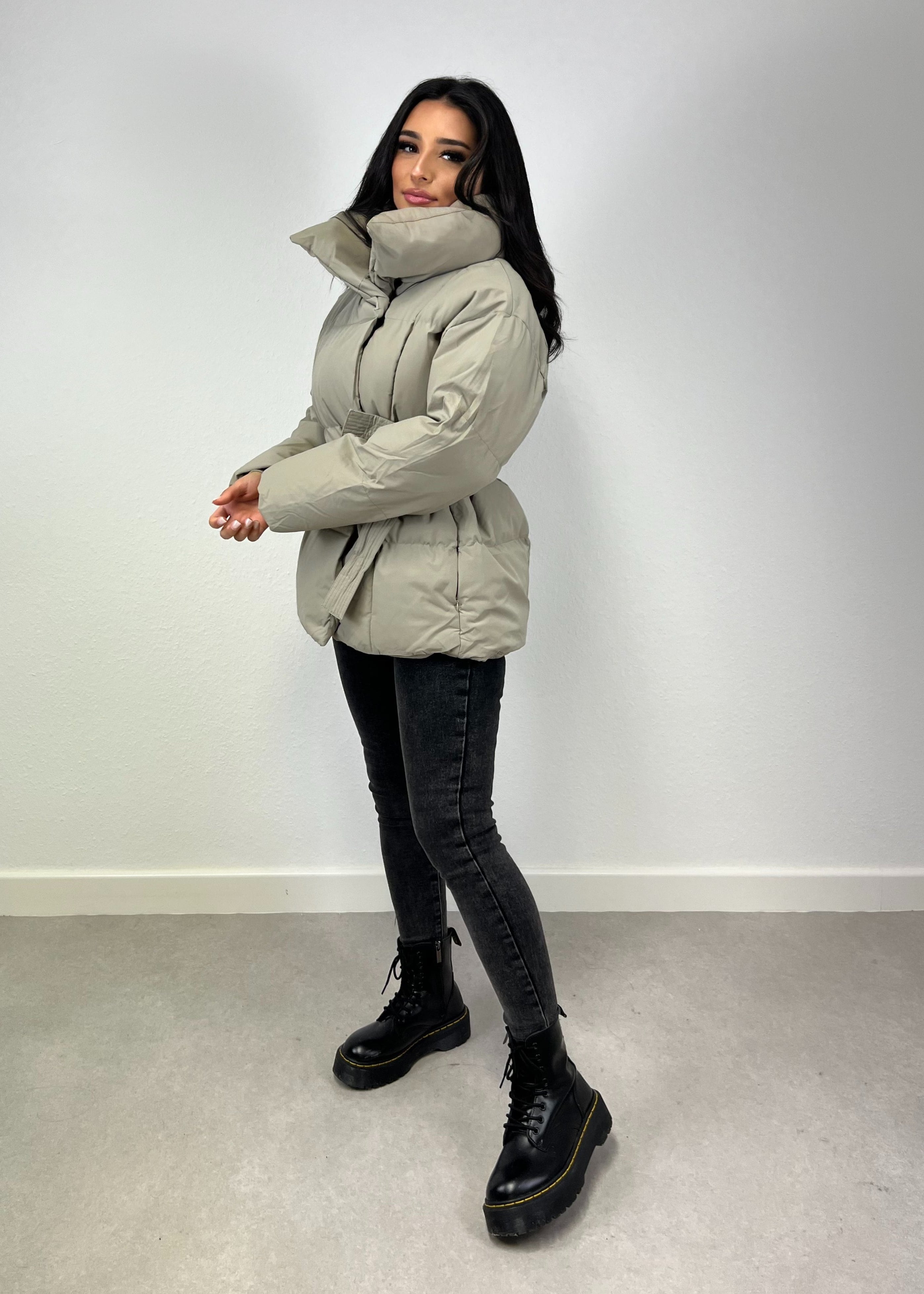 Modell trägt eine kurze Damen Steppjacke mit Taillengürtel – NAHA Fashion