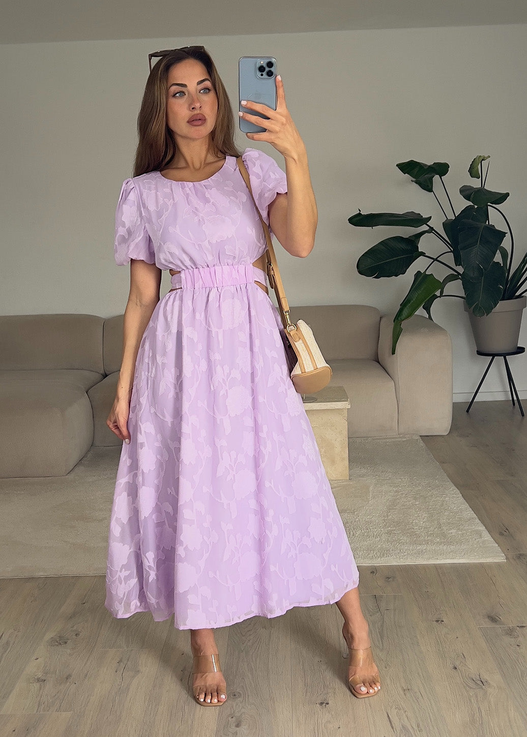 Frau trägt ein fliederfarbenes Kleid mit Puffärmeln – romantischer Sommerlook von NAHA