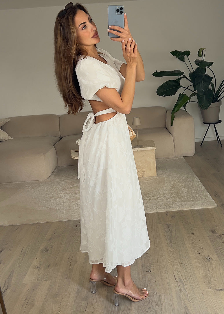 Frau trägt ein weißes Kleid mit Puffärmeln und tailliertem Schnitt – Sommermode von NAHA