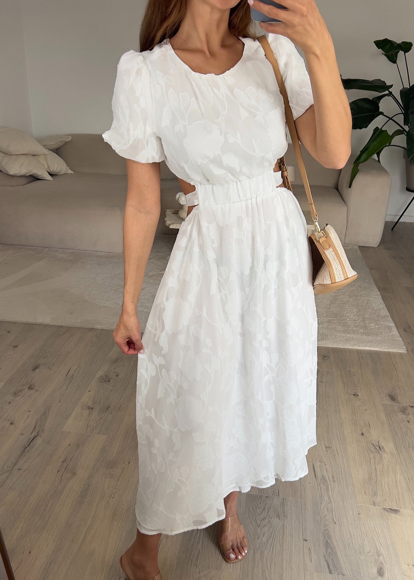 Frau trägt ein weißes Kleid mit Puffärmeln und tailliertem Schnitt – Sommermode von NAHA