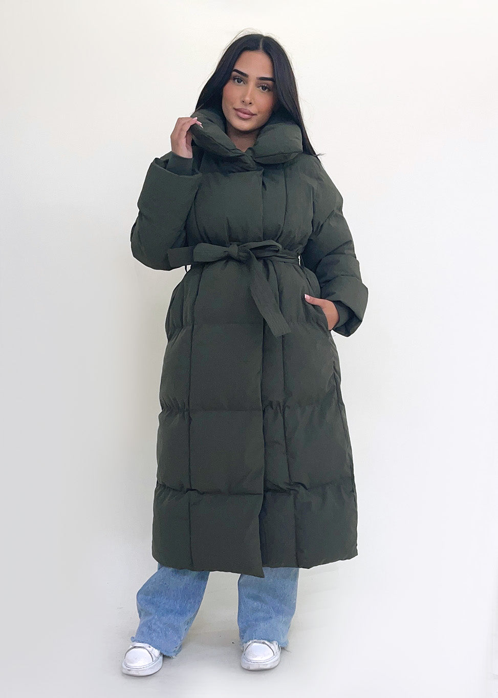 Frau trägt lange Winterjacke in Khaki mit Gürtel & hohem Kragen Front– NAHA Winterlook