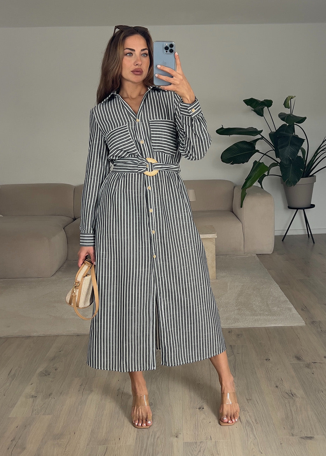 Frau trägt ärmelloses, langes Hemdkleid in Schwarz mit Knopfleiste – eleganter Sommerlook von NAHA