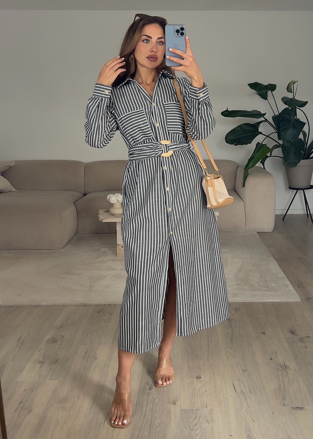 Frau trägt ärmelloses, langes Hemdkleid in Schwarz mit Knopfleiste – eleganter Sommerlook von NAHA