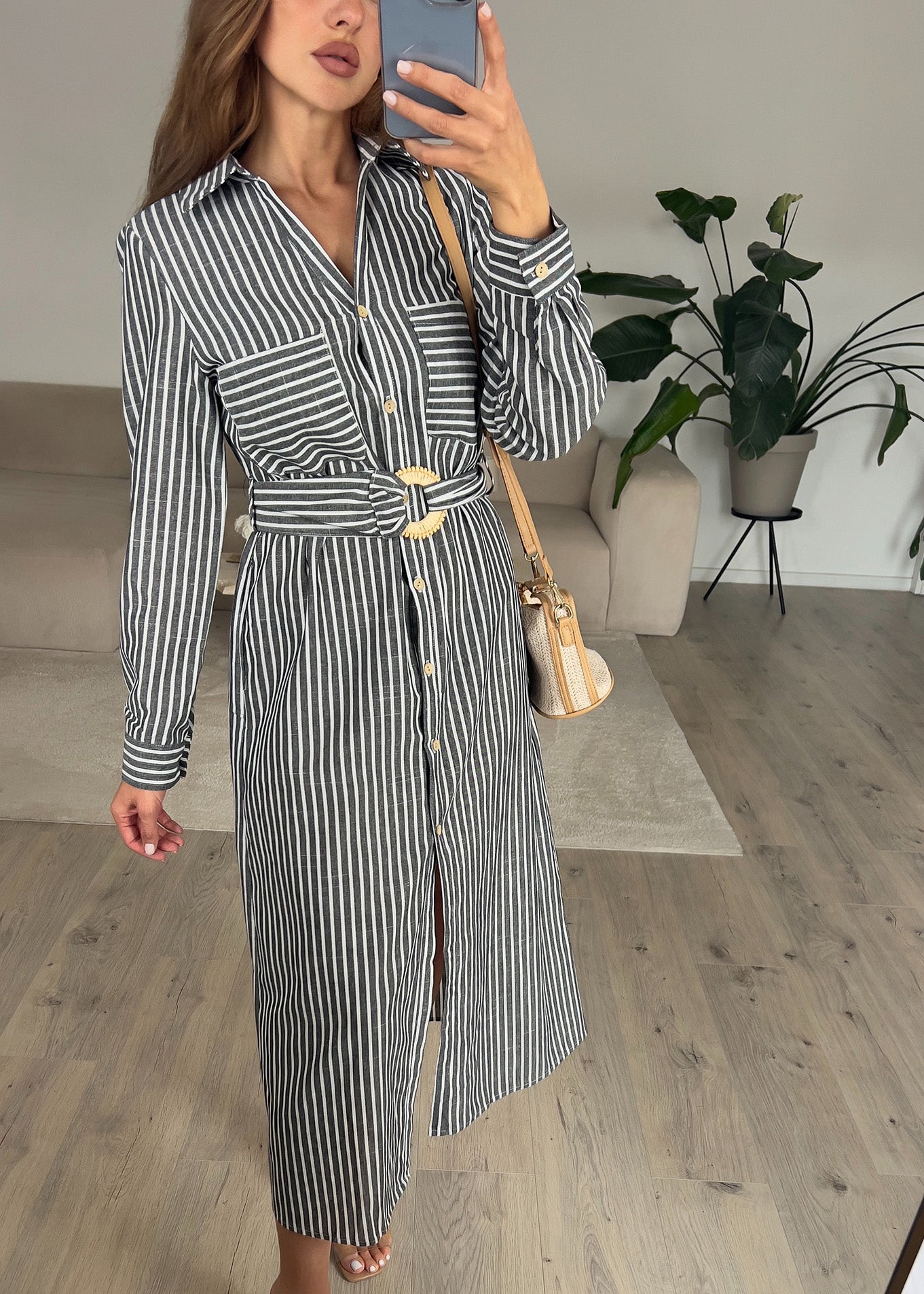 Frau trägt ärmelloses, langes Hemdkleid in Schwarz mit Knopfleiste – eleganter Sommerlook von NAHA