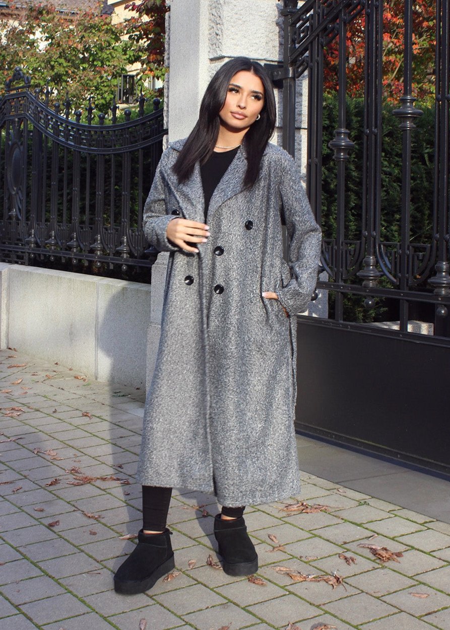 Frau trägt grauen Mantel mit Knopfverschluss – klassischer Übergangslook von NAHA