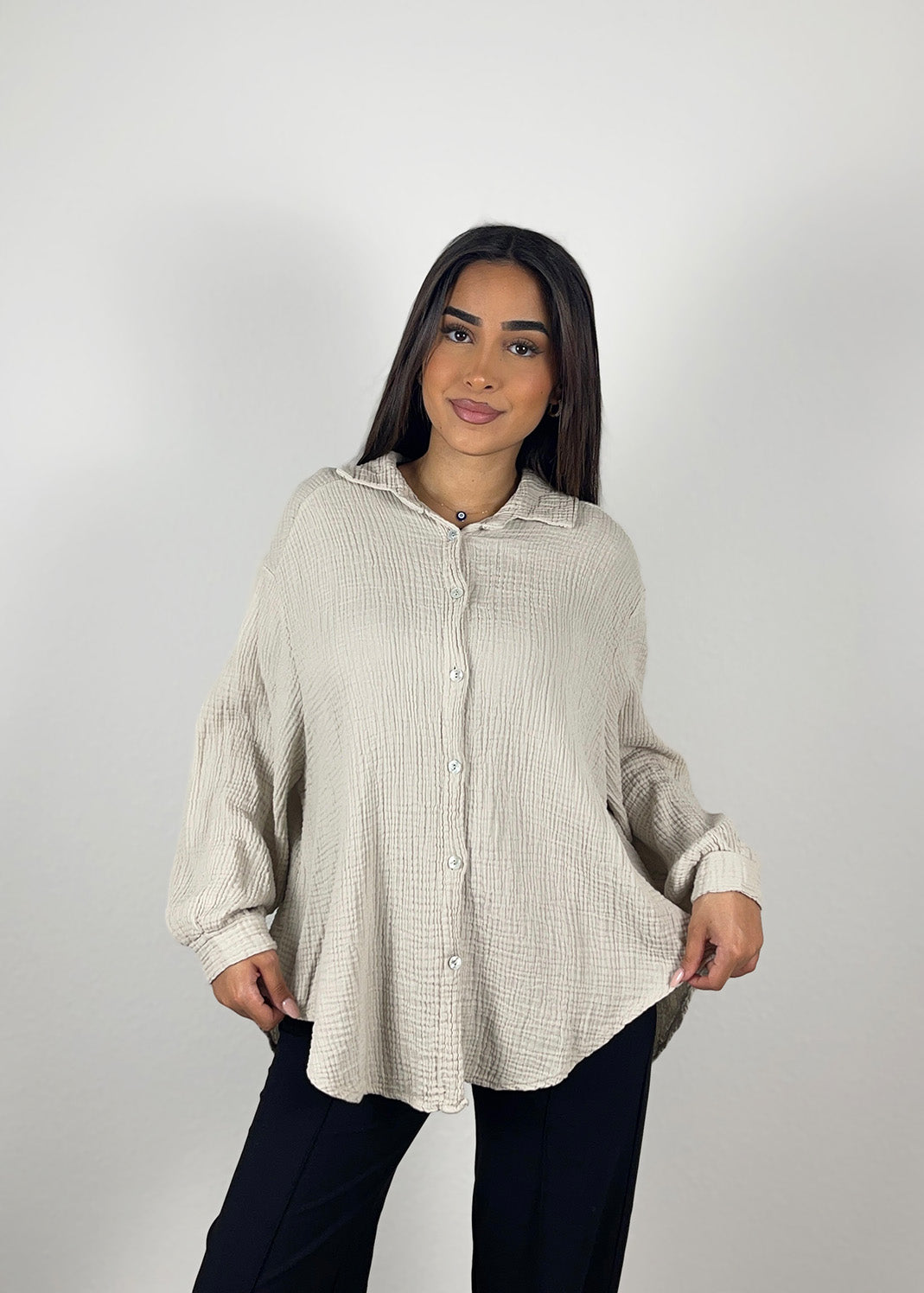 Frau trägt beige Musselin-Bluse aus Baumwolle – luftiger, natürlicher Sommerlook von NAHA