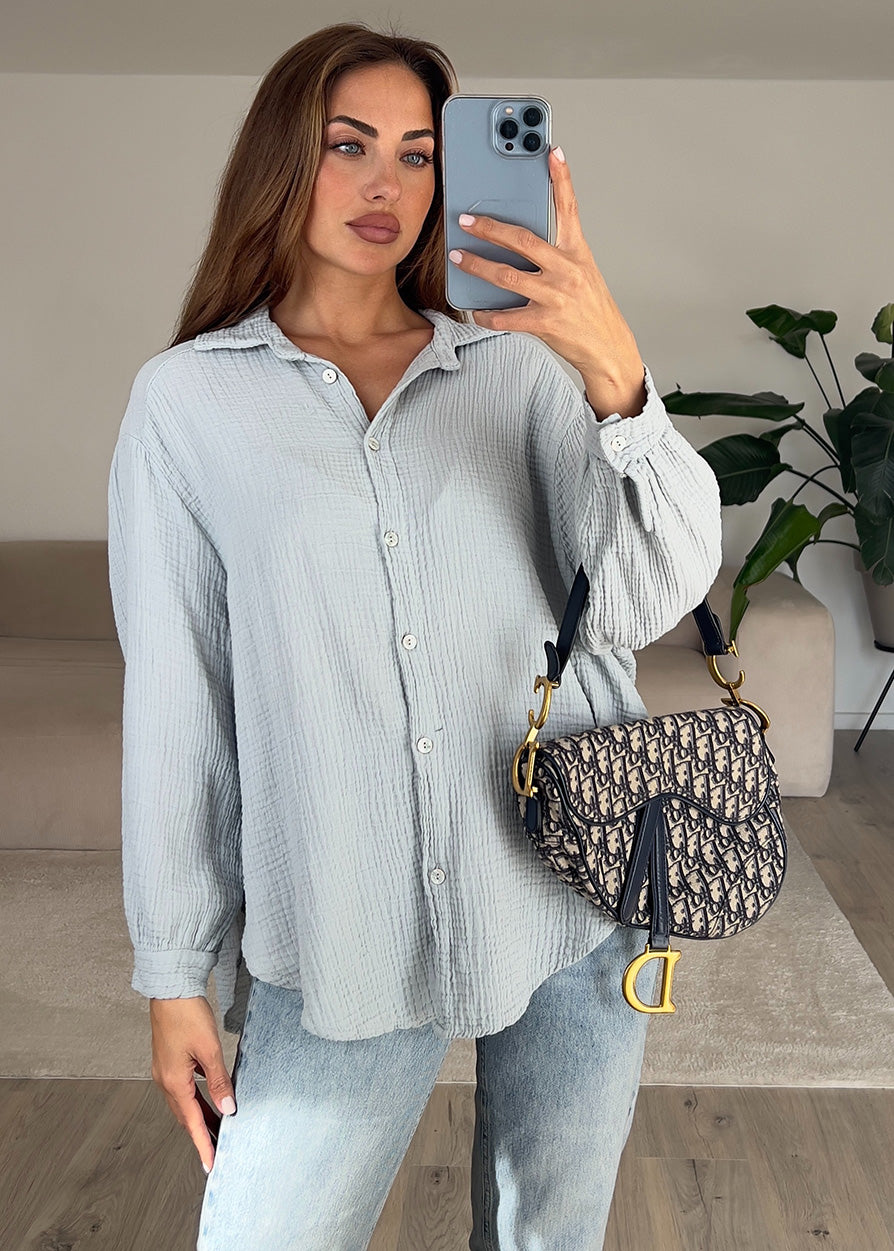 Frau trägt hellgraue Musselin-Bluse aus Baumwolle – moderner, cleaner Look von NAHA