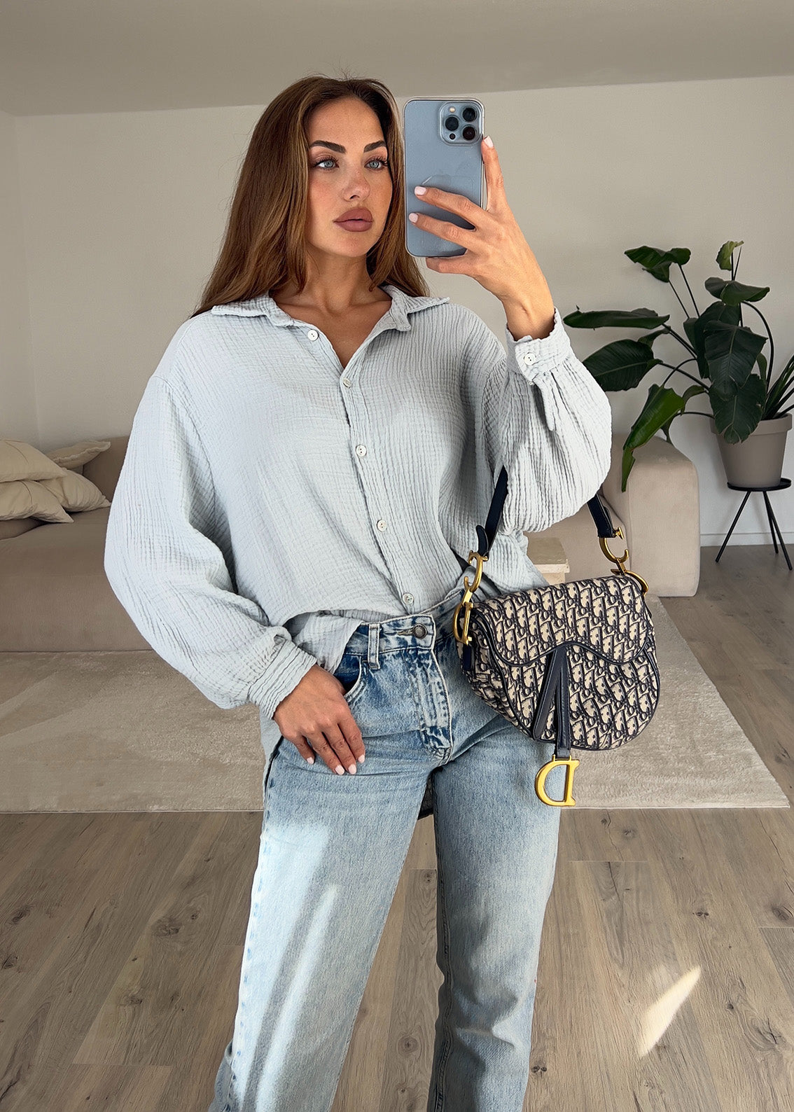 Frau trägt hellgraue Musselin-Bluse aus Baumwolle – moderner, cleaner Look von NAHA