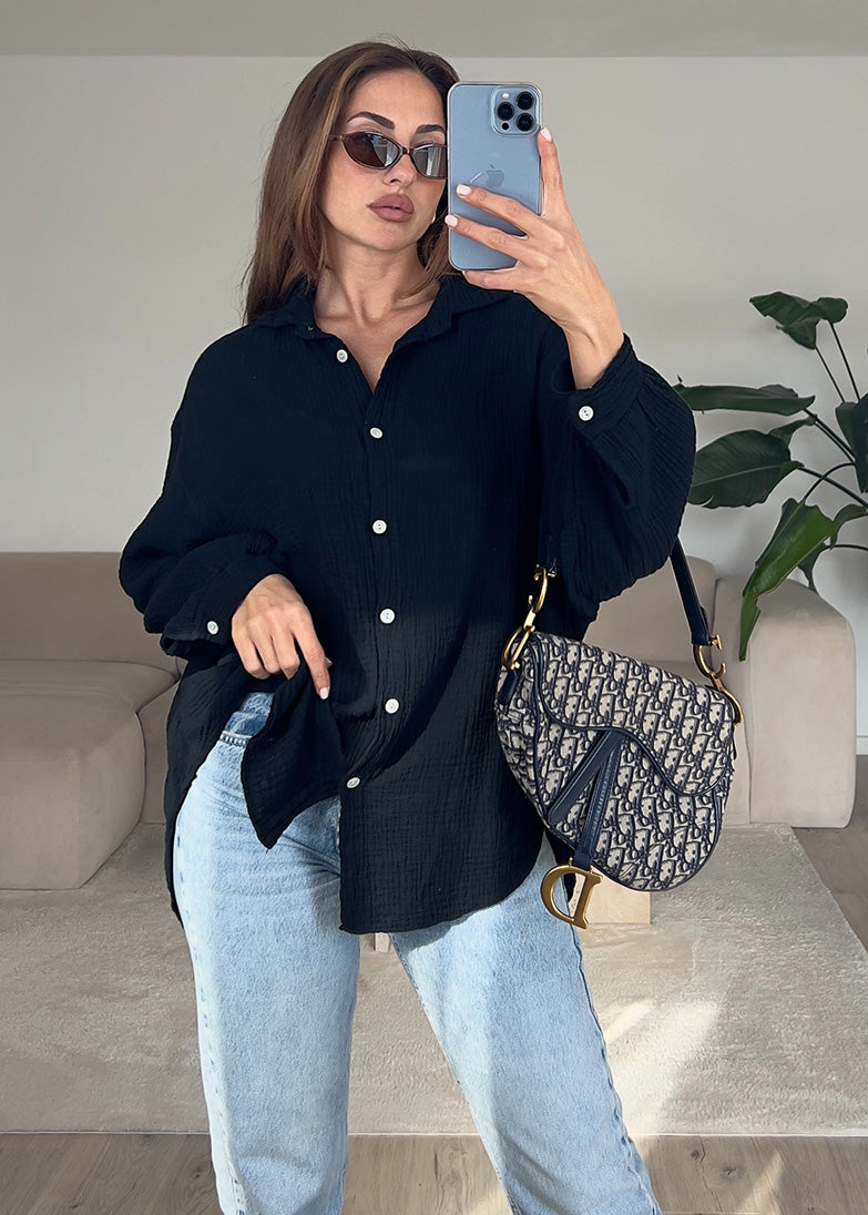 Frau trägt schwarze Musselin-Bluse aus Baumwolle – moderner, luftiger Look von NAHA