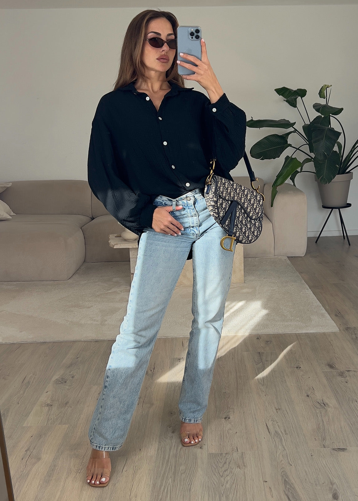 Frau trägt schwarze Musselin-Bluse aus Baumwolle – moderner, luftiger Look von NAHA