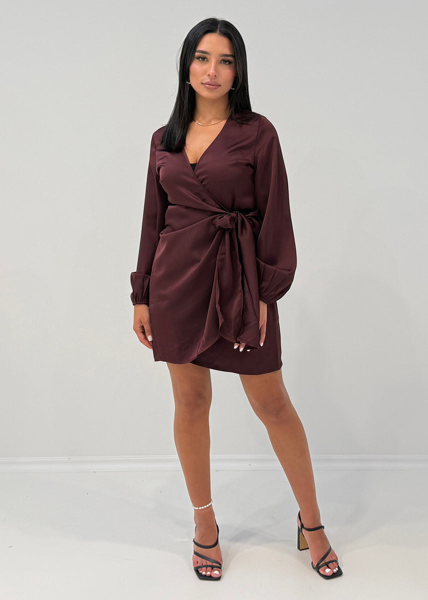 Modell trägt ein kurzes Damen Satinkleid mit Wickelausschnitt und Bindegürtel – NAHA Fashion