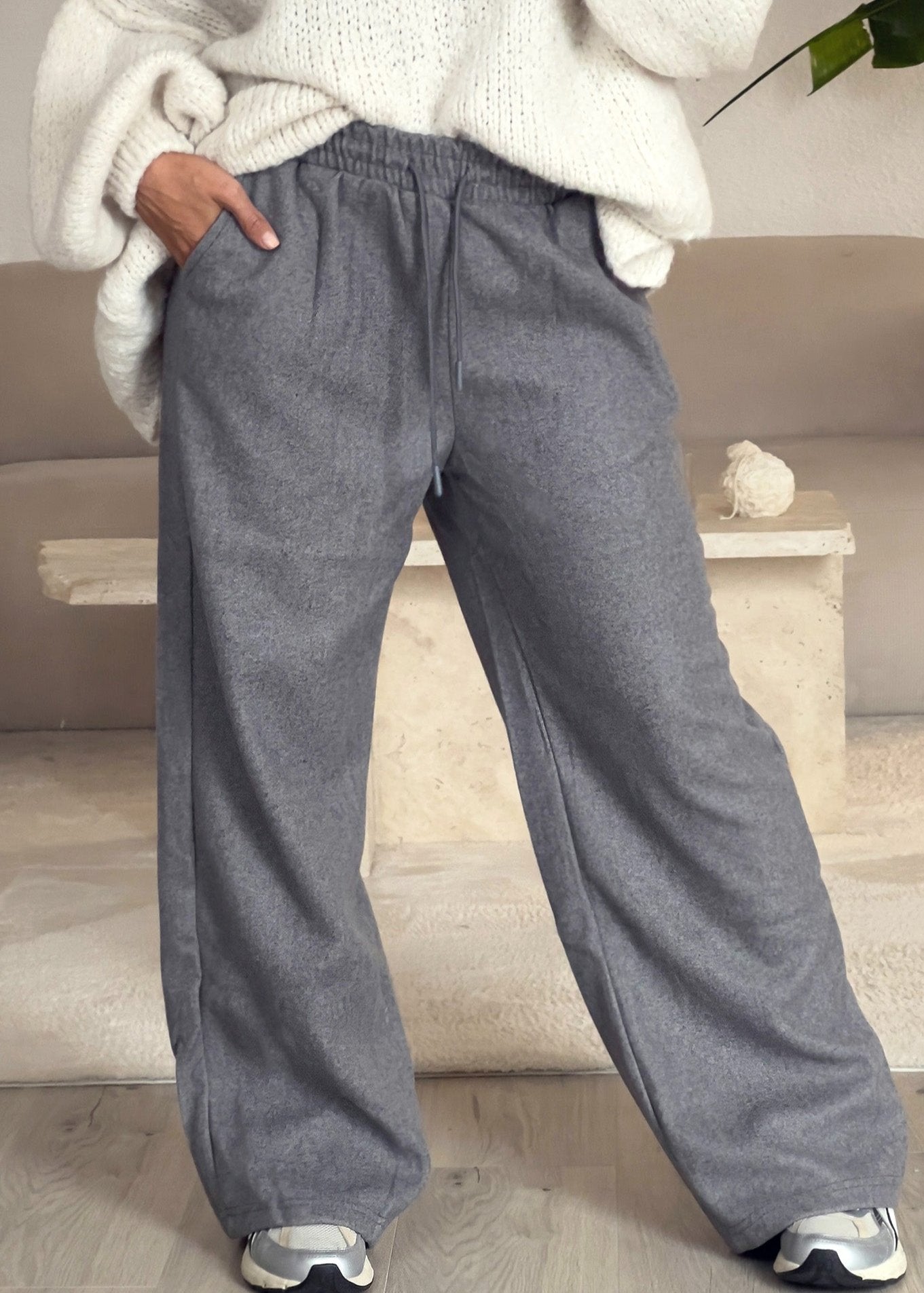 Frau trägt graue Straight Sweat Pants mit elastischem Bund – bequemer Alltagslook von NAHA