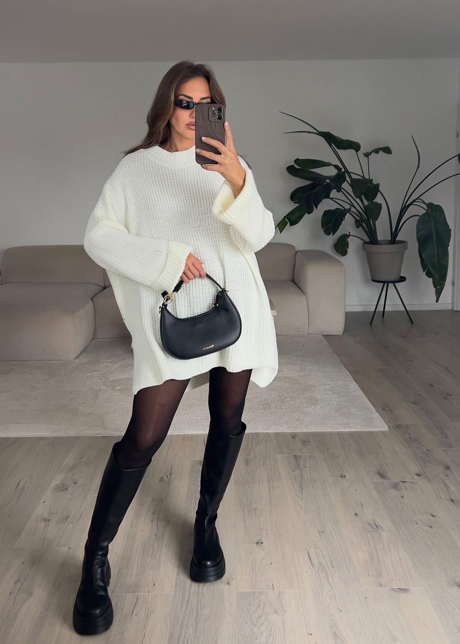 Frau trägt weißen Strickpullover mit lockerer Passform – klassischer Alltagslook von NAHA