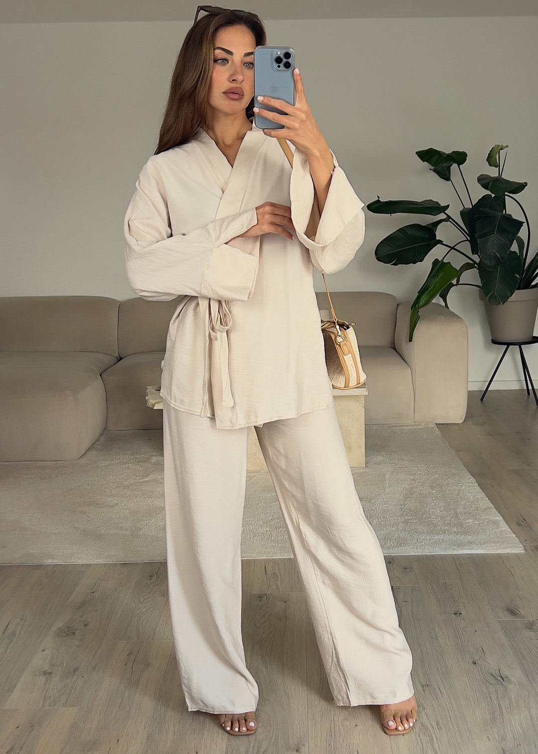 Modell trägt einen Basic-Zweiteiler in Wickeloptik in hellem Beige – mit Wickeloberteil und weiter Hose