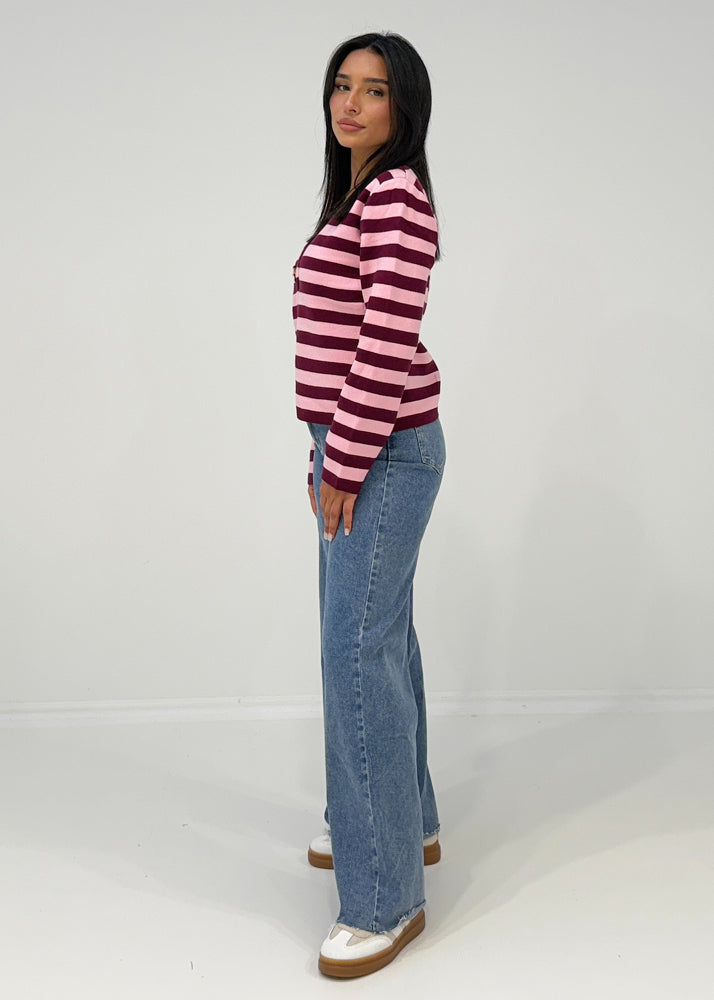 Gestreiftes Oberteil mit tiefem V-Ausschnitt und glänzendem Zierknopf, getragen zu Hose in Wildlederoptik
