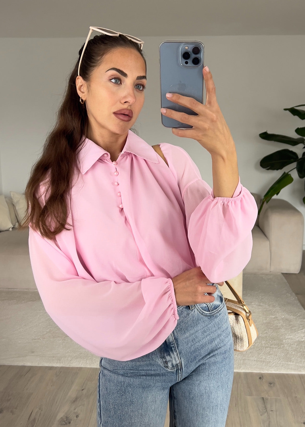 Modell trägt eine rosa Hemdbluse mit geradem Schnitt, Knopfleiste und klassischem Kragen