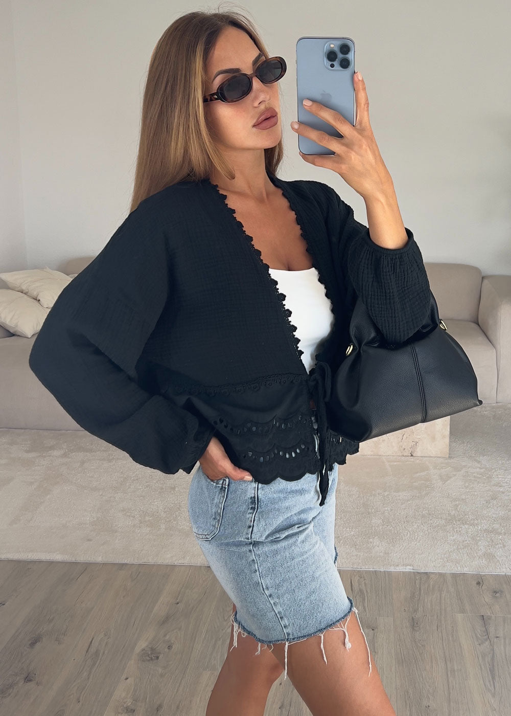 Schwarze Musselin-Bluse mit Lochstickerei und Bindegürtel