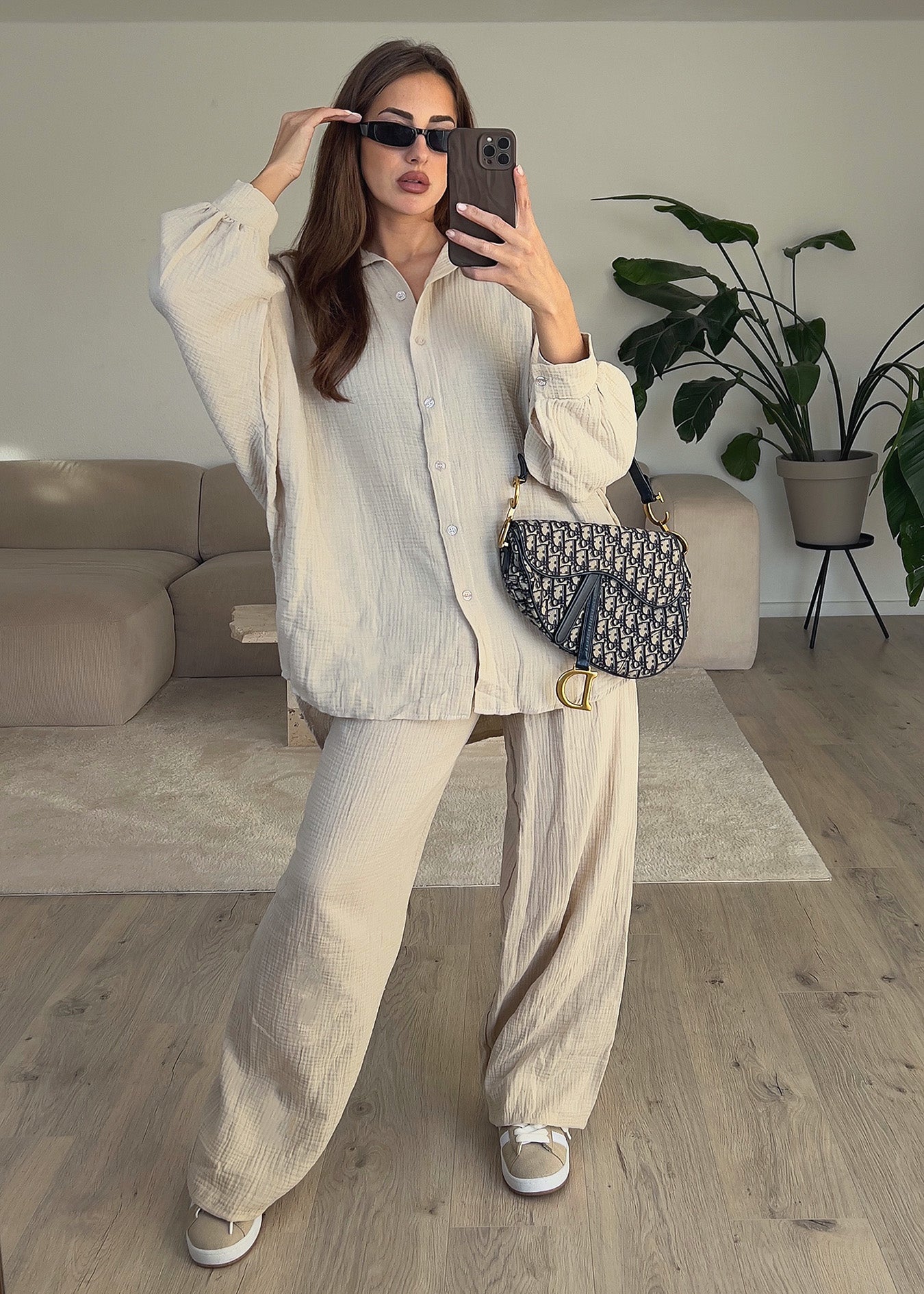 Modell trägt ein Musselin Set in hellem Beige mit Oversize-Hemd und weiter Hose – lässig und natürlich gestylt