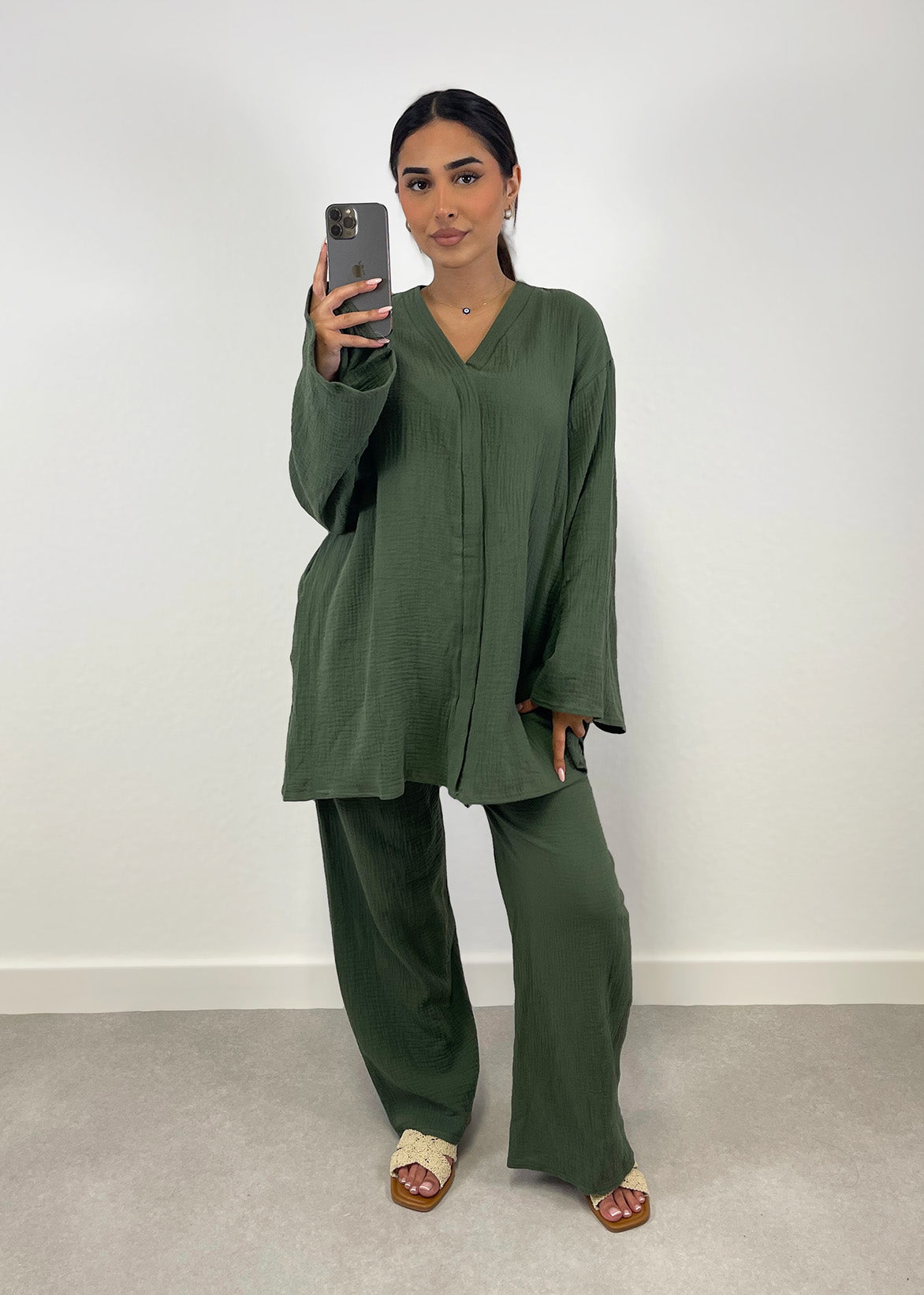 Frau trägt khakifarbenen Musselin-Zweiteiler mit Oversize-Bluse und weiter Hose, frontale Ansicht