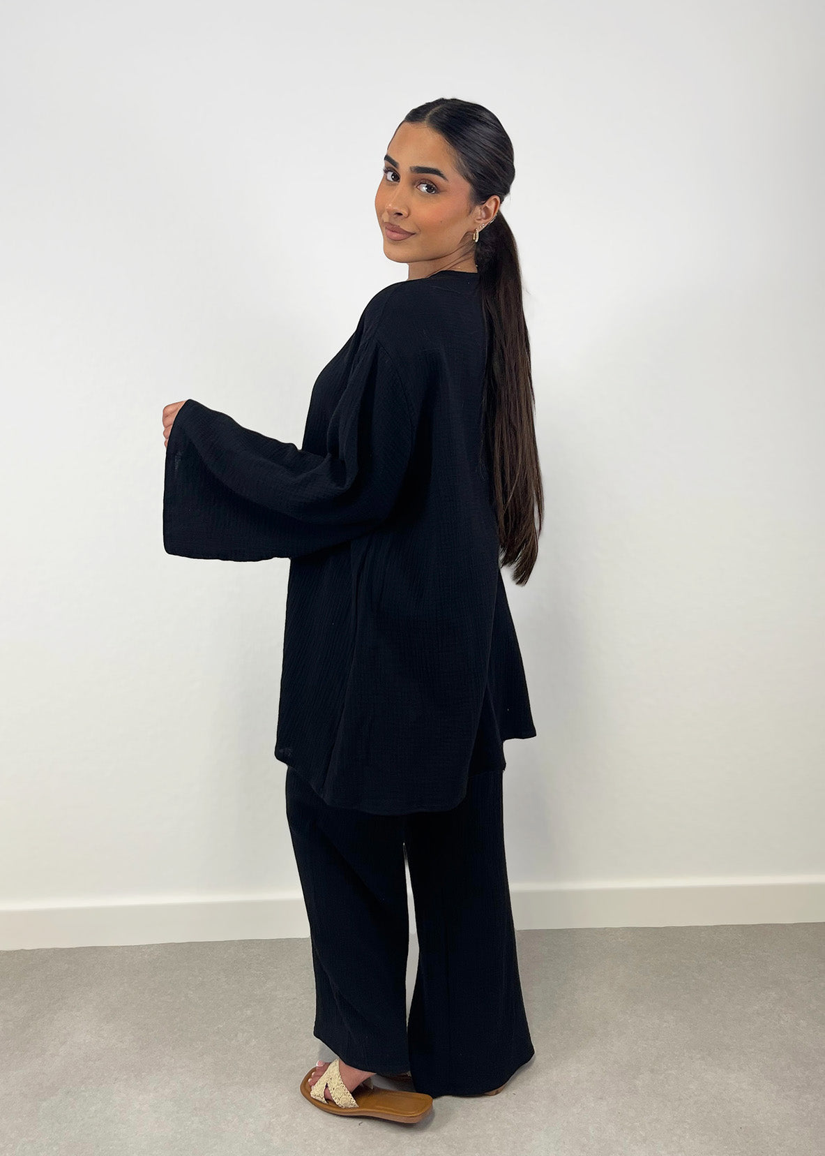 Rückansicht des schwarzen Musselin-Zweiteilers mit lockerer Passform und geradem Fall