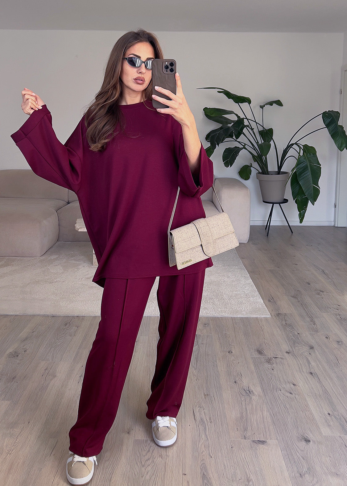 Modell trägt einen dunkelroten Oversize Zweiteiler mit lockerem Oberteil und weiter Hose – ideal für stilvolle Alltagslooks
