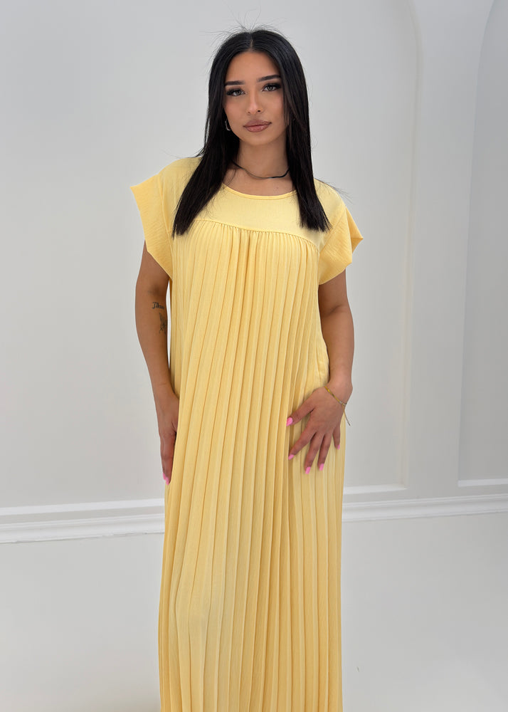 Frau trägt ärmelloses Maxikleid mit feiner Plissierung – luftiges Sommerkleid aus der NAHA Kollektion