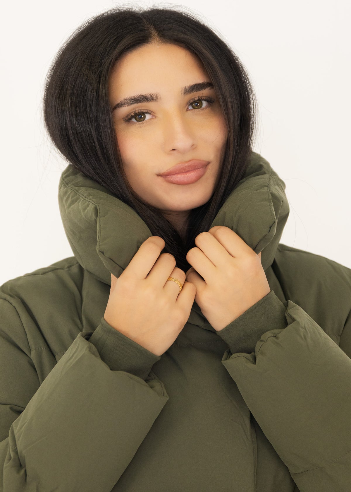 Nahaufnahme: Model hält den XXL-Kragen des khaki Mantels hoch