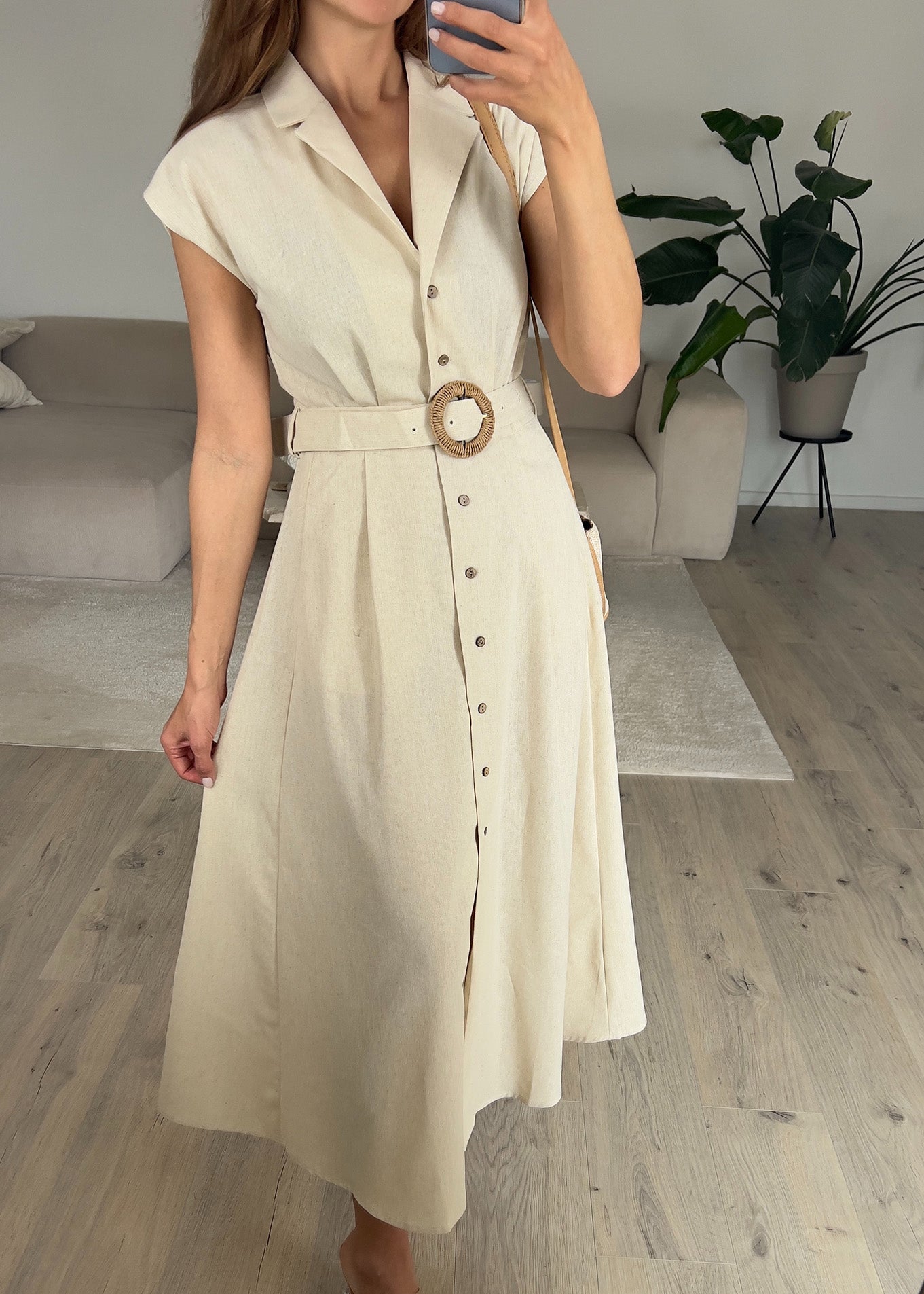 Frau trägt ärmelloses Hemdkleid in Beige mit Knopfleiste – Sommerlook von NAHA