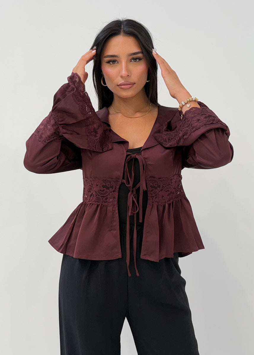 Modell trägt eine Damen Satinbluse mit Spitze, ausgestellten Ärmeln und Bindeband – NAHA Fashion