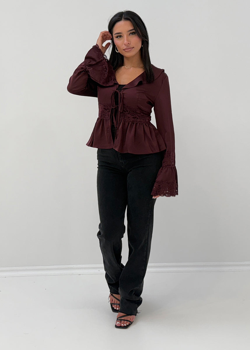 Modell trägt eine Damen Satinbluse mit Spitze, ausgestellten Ärmeln und Bindeband – NAHA Fashion