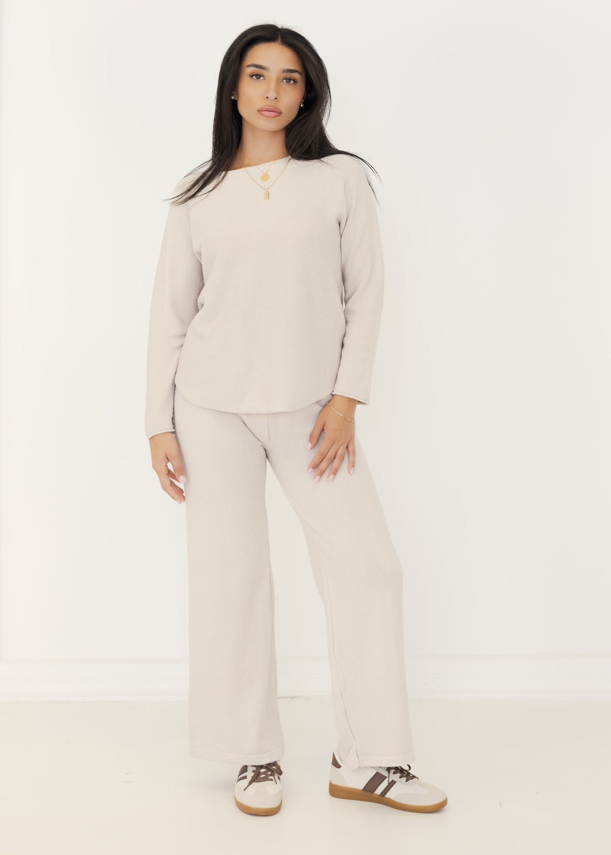 Damen Strick-Zweiteiler in Beige aus Pullover und weiter Strickhose, getragen mit Sneakern