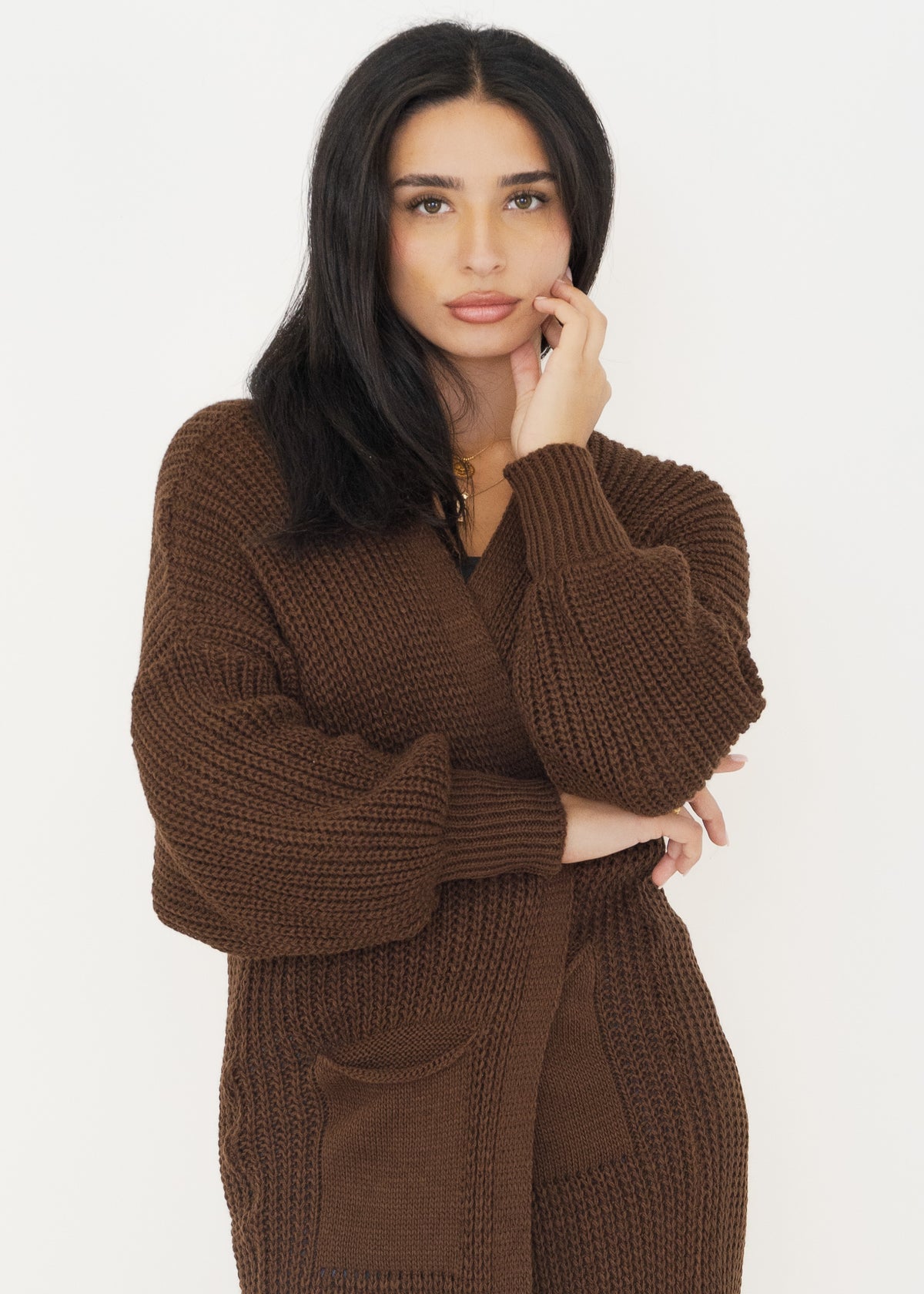 Nahaufnahme der braunen Strickjacke mit Ballonärmeln, Rippbündchen und Tasche