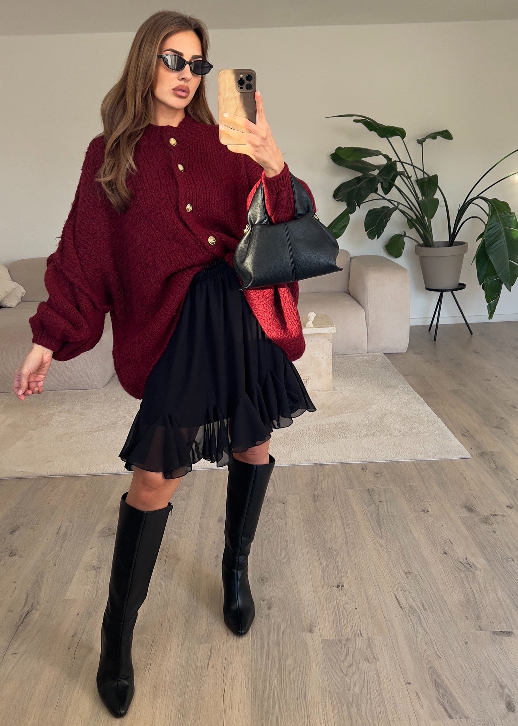 Modell trägt einen schwarzen Volantrock mit eleganter Raffung und luftiger Passform – vielseitig kombinierbar für Tag und Abend