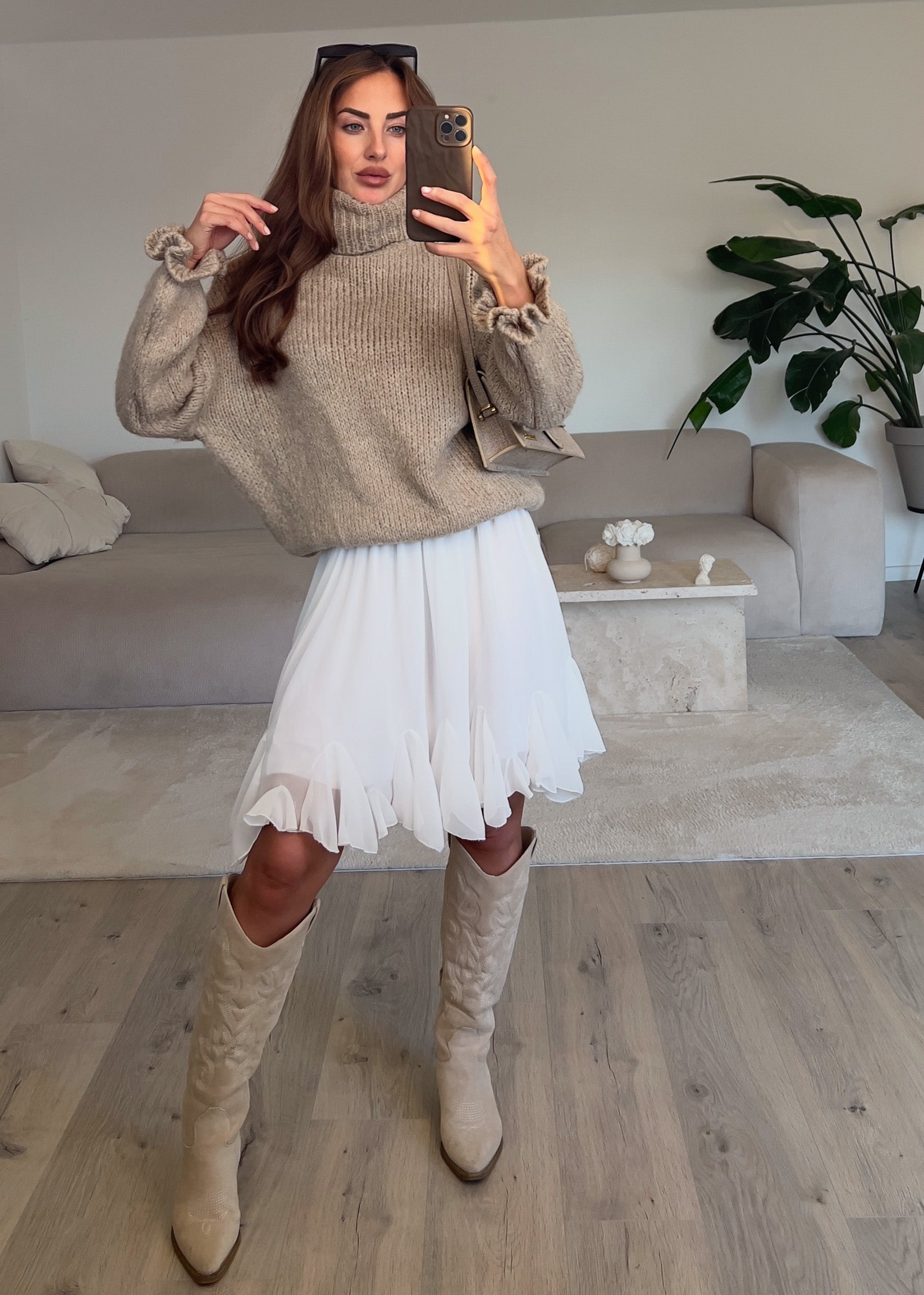 Modell trägt einen weißen Volantrock mit Rüschen und fließender Silhouette – sommerlich, elegant und vielseitig kombinierbar