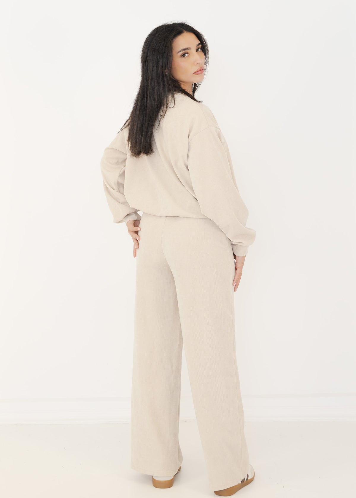 Rückansicht des Damen Strick-Zweiteilers in Beige mit weiter Strickhose