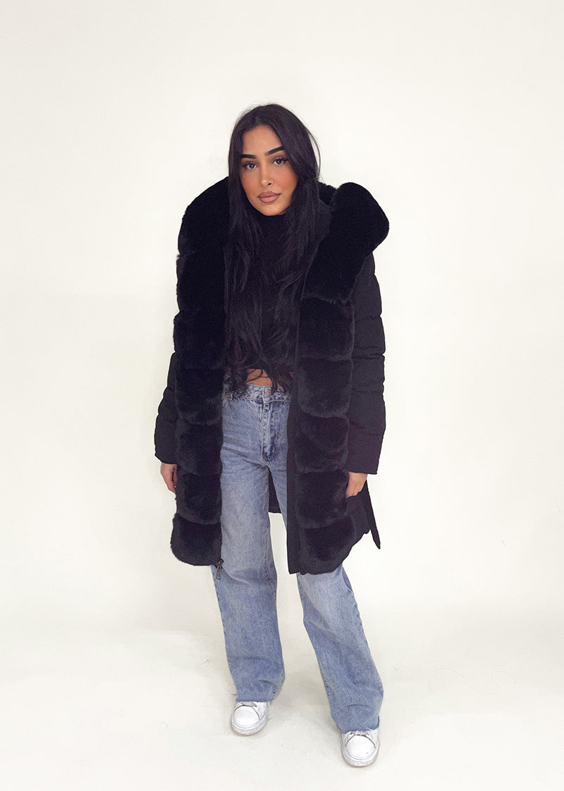 Modell trägt eine taillierte Damen Steppjacke mit Kunstfellbesatz und Gürtel – NAHA Fashion