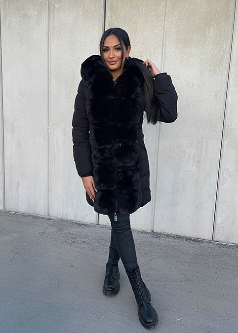 Modell trägt eine taillierte Damen Steppjacke mit Kunstfellbesatz und Gürtel – NAHA Fashion