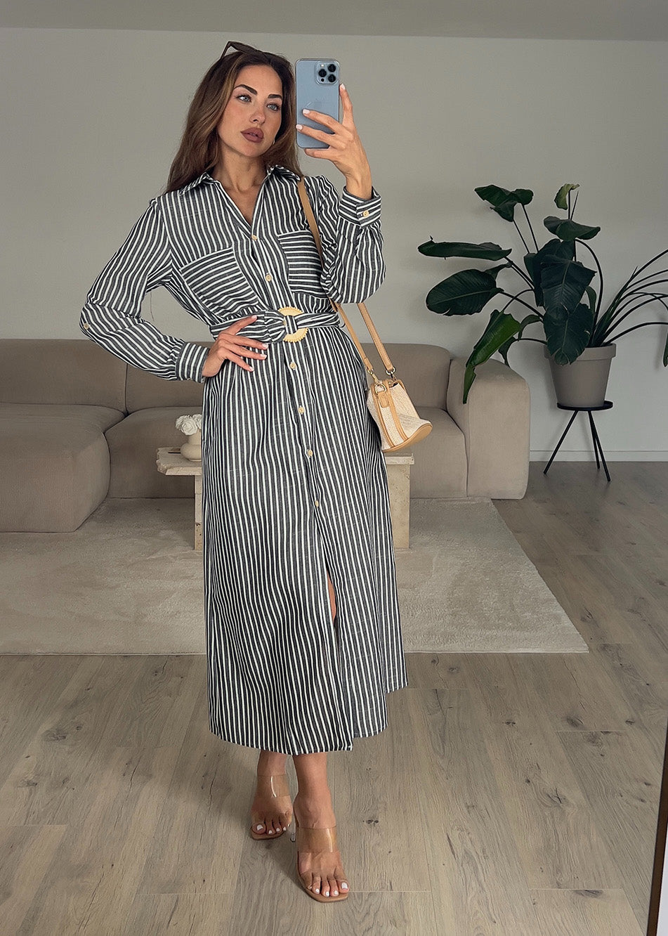 Frau trägt ärmelloses, langes Hemdkleid in Schwarz mit Knopfleiste – eleganter Sommerlook von NAHA