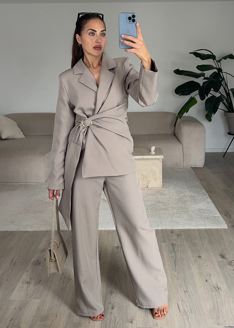 Modell trägt einen taillierten Blazer-Zweiteiler in Taupe mit Gürtel und weitem Bein – eleganter Look für Büro oder Event