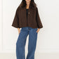 Damen Cape-Jacke in Braun mit Fellkragen, offen getragen zu blauer Wide-Leg-Jeans